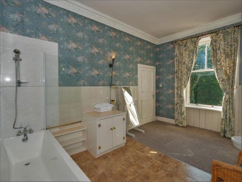 y baño con bañera y lavamanos. en Clonyard House Hotel, en Dalbeattie