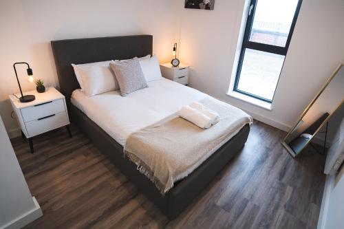 a bedroom with a large bed with white sheets and a window at Kelham Gate 1-Bed Apartments - City Centre - New - FREE Wi-Fi in Sheffield