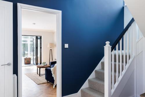 a hallway with blue walls and a stairway with a blue wall at Ashtree House in Barton on Sea