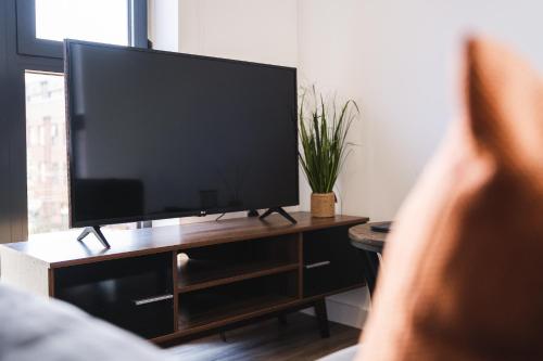 a person with their feet up in front of a television at Central Studio - New - FREE Wi-Fi - City Centre in Sheffield