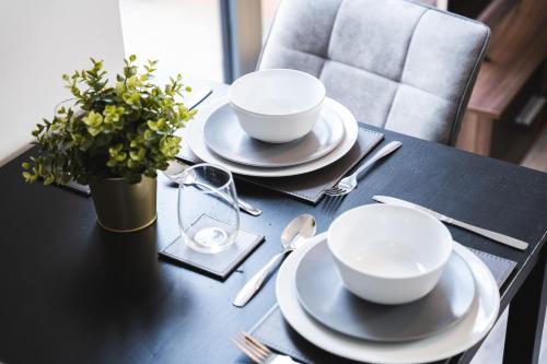 a black table with two white bowls and a plant on it at Central Studio - New - FREE Wi-Fi - City Centre in Sheffield