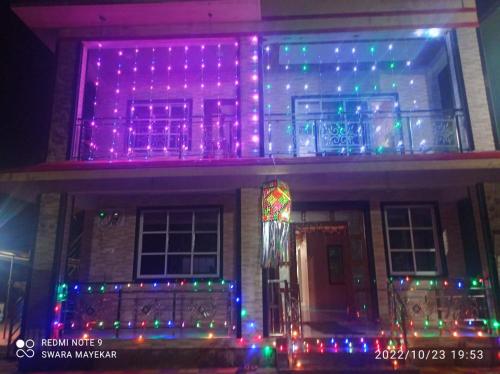 a house with christmas lights on the front of it at Priyansh Home stay in Harihareshwar