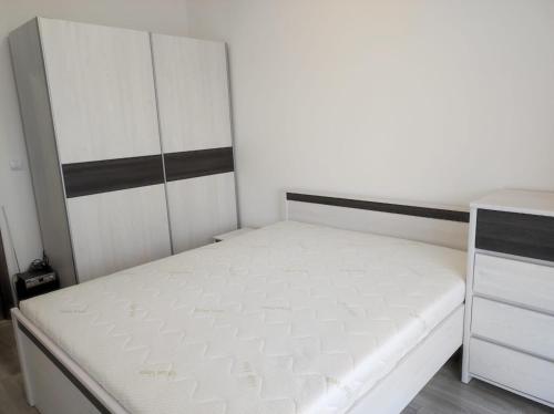 a small bedroom with a bed and a dresser at Apartament Parkowa in Olecko