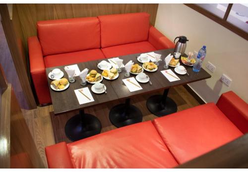 a table with plates of food on it with two red chairs at Ibis Lagos Airport in Ikeja