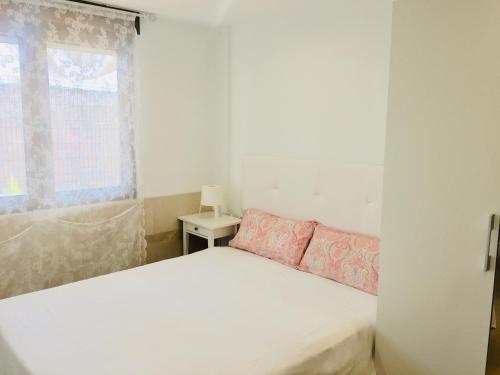 a bedroom with a white bed and a window at APARTAMENTO Luis in Suances
