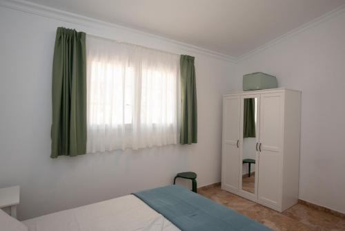 1 dormitorio con 1 cama, vestidor y ventana en Drago, en Agüimes