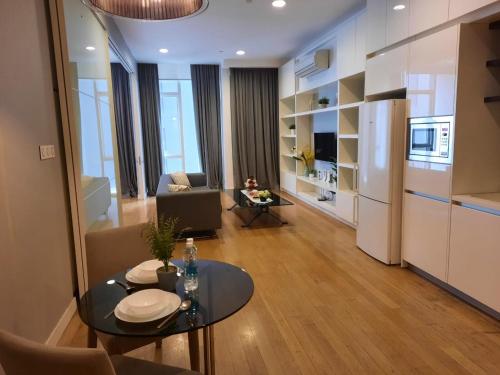 a living room with a table and a kitchen at Platinum Suites Klcc by Signature Apartment in Kuala Lumpur