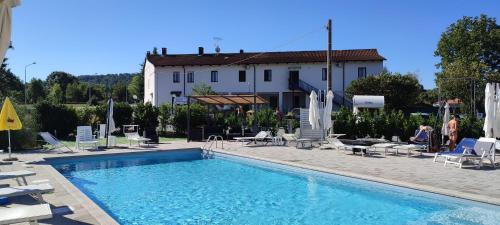 una piscina con sedie e un edificio sullo sfondo di Nautica Tarello - Casa Ena BeB a Viverone