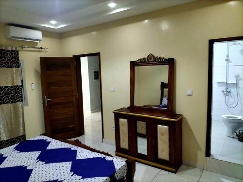 a bedroom with a mirror and a bed and a bathroom at Maison d'Hôtes entière Cité Douane Golf Dakar in Dakar