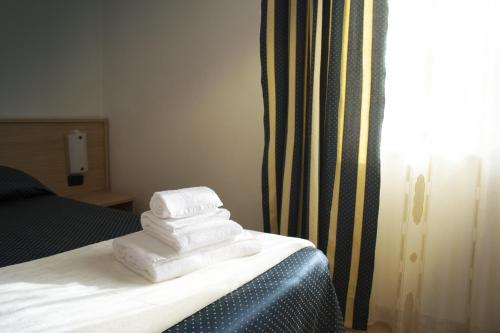 a pile of towels sitting on top of a bed at Residence La Quiete in Alba