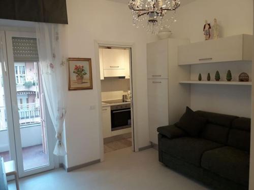uma sala de estar com um sofá e uma cozinha em Appartamento vittoria em Pietra Ligure