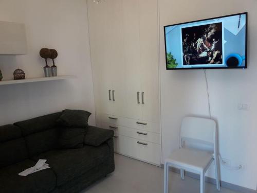 sala de estar con sofá y TV en la pared en Appartamento vittoria, en Pietra Ligure