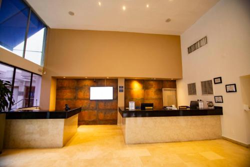 a lobby with a reception desk in a building at Hotel Barranquilla Plaza in Barranquilla