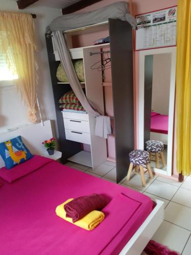 1 dormitorio con 2 literas y alfombra rosa en Pinpin, en Pointe-Noire