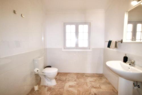 een witte badkamer met een toilet en een wastafel bij Wohnung Esterlizia in Agüimes