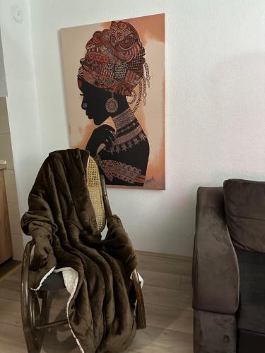 a woman sitting in a chair with a blanket at ANKA APARTMENT in Štip
