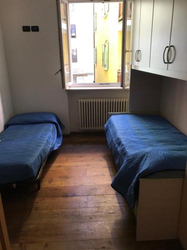 2 camas en una habitación pequeña con ventana en Casa Stablum, en Malè