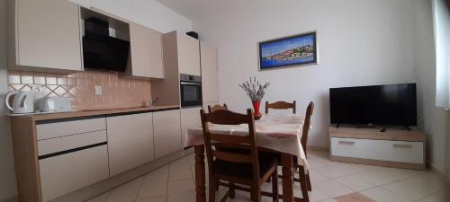 a kitchen with a dining table and a television at Apartments Sara in Kali