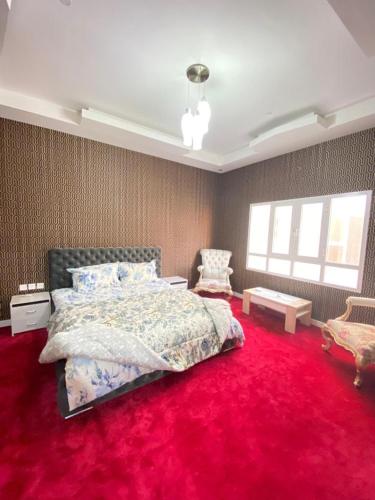 a bedroom with a bed and a red carpet at Pool and Steam room House in the heart of Muscat in Muscat
