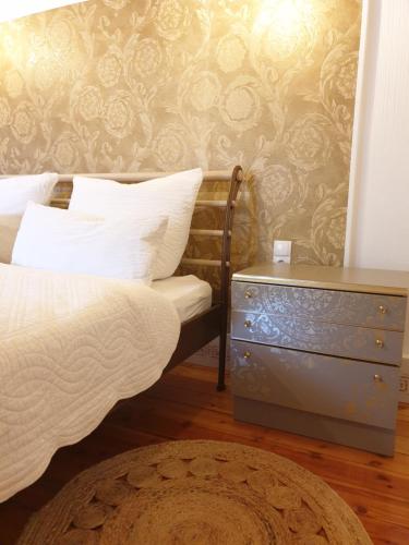 a bedroom with a bed and a dresser and a wall at Stillvolle Designwohnung im historischen Zentrum in Stolberg i. Harz