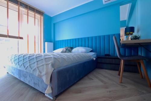 um quarto azul com uma cama com um cão deitado sobre ela em 5-star apartment em Gliwice