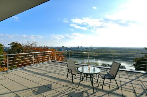 a patio with a table and chairs on a balcony at River View Apartments Hotel in Bratislava