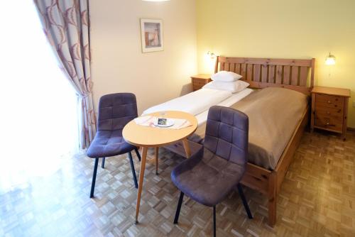 una camera d'albergo con letto, tavolo e sedie di Pension Seiwald in Kötschach a Kötschach-Mauthen