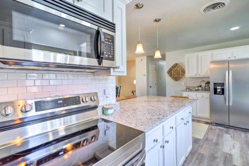 a kitchen with a stove and a microwave at Merritt Island Oasis with Pool about 7 Mi to Beach! in Merritt Island