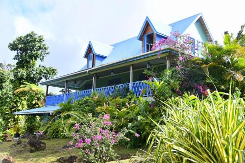 a house with a blue porch and some flowers at Harmony Villa in Pont Cassé