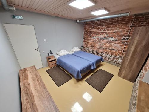 a bedroom with a blue bed in a brick wall at Narva Port Hostel in Narva