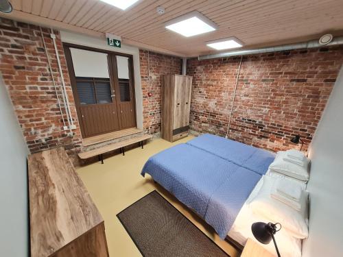 een slaapkamer met een bed in een bakstenen muur bij Narva Port Hostel in Narva