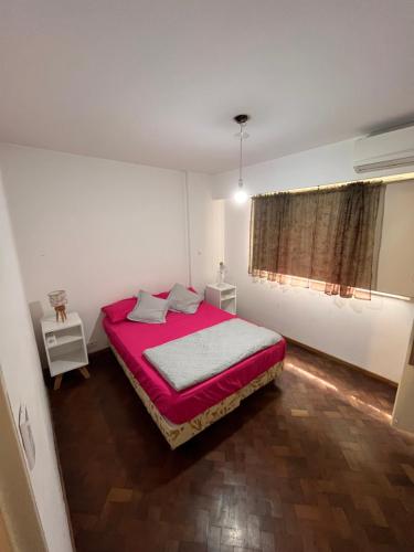 1 dormitorio con 1 cama grande con manta roja en Hermoso departamento céntrico de dos ambientes. en Rosario