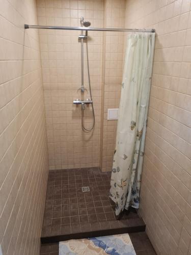 a shower with a shower curtain in a bathroom at Narva Port Hostel in Narva