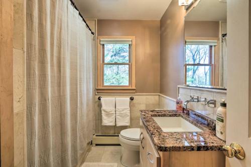 a bathroom with a toilet and a sink and a window at Family-Friendly Woodbury Home with Yard and Deck! in Woodbury