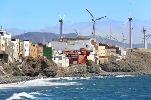 un groupe de bâtiments sur une colline avec turbines éoliennes dans l'établissement Sweet Home Pozo Izquierdo A, à Pozo Izquierdo