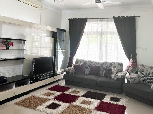 een woonkamer met een bank en een flatscreen-tv bij Muar Homestay [Located at Sabak Awor Seafood Court] in Muar