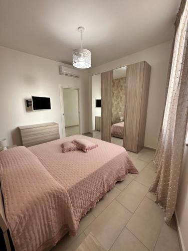 una camera con un letto e una coperta rosa di Casa Lulú a Napoli