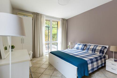 sypialnia z łóżkiem z niebiesko-białym kocem w obiekcie Portobello Apartments w Bolonii