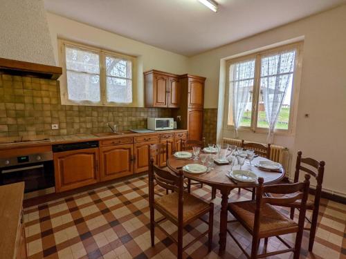 une cuisine avec une table en bois avec des chaises et un plateau de table dans l'établissement Maison au calme avec jardin privé et WIFI, idéale pour la famille - FR-1-653-21, à Blanzaguet-Saint-Cybard-le-Peyrat