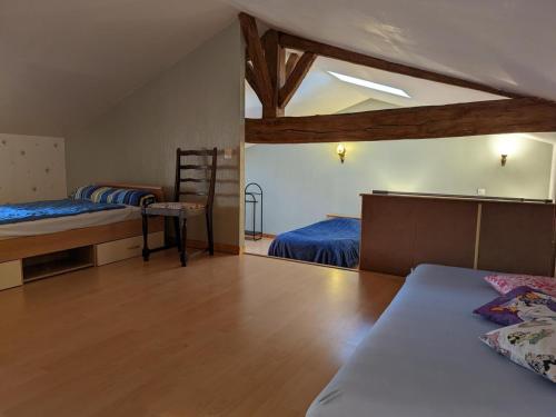 a bedroom with two beds and a wooden floor at Gîte familial avec piscine, jardin clos, équipements bébé, animaux acceptés, Chadurie - FR-1-653-61 in Chadurie
