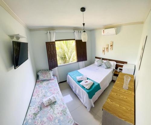 a bedroom with two beds and a window at Pousada Carvalhos - Camaçari in Camaçari