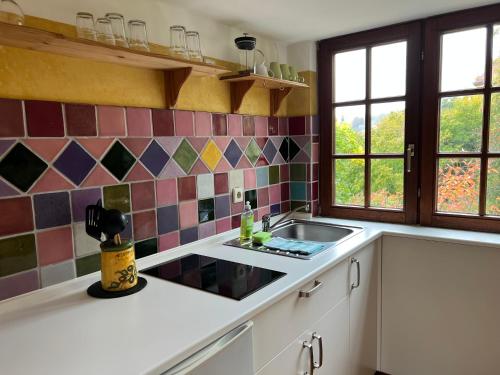 cocina con fregadero y azulejos en la pared en Petite Bellevue, en Baden-Baden