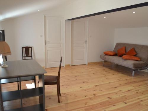 a living room with a couch and a chair at Gîte Charentais avec piscine, terrasse, et pêche - confort moderne et charme rural - FR-1-653-87 in Salles-de-Barbezieux