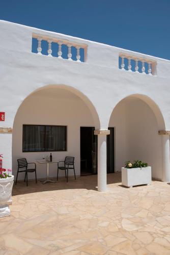 a large white building with chairs and a table at Palmera in Agüimes