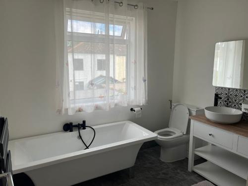 La salle de bains est pourvue d'une baignoire, de toilettes et d'une fenêtre. dans l'établissement Shared house on Lakewood crescent, à Bristol