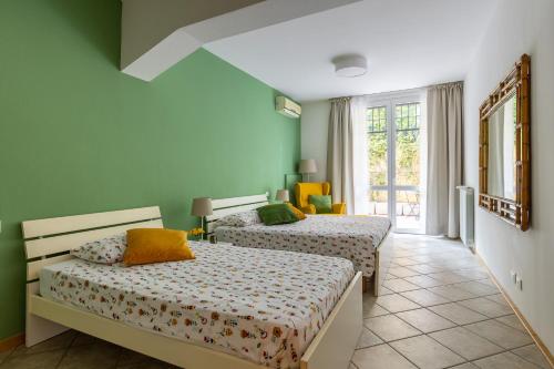 two beds in a room with green walls at Portobello Apartments in Bologna