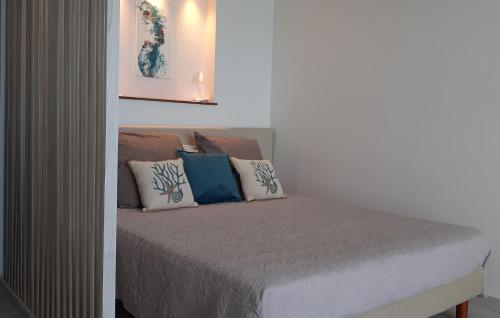 una cama con almohadas en una habitación en Grand Studio « Blue Sunset » mer, plage, piscine., en Marigot