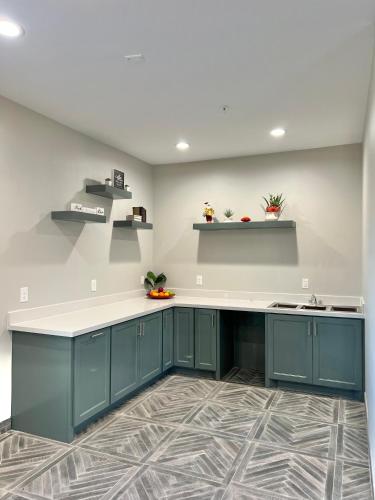 a kitchen with blue cabinets and white counter top at The Residency Suites in Sugar Land