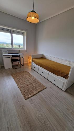 a bedroom with a bed and a desk and a table at Piso Panorama in Oliveira do Bairro