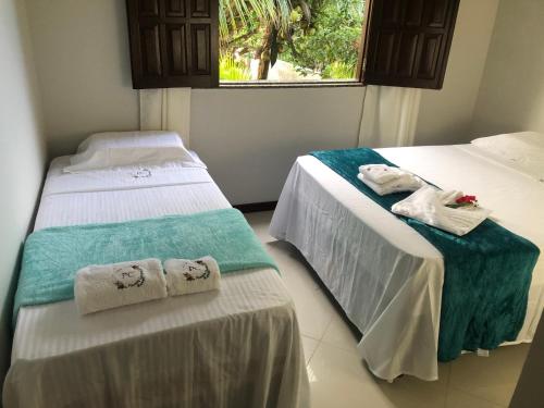 duas camas com toalhas num quarto em Pousada Carvalhos - Camaçari em Camaçari